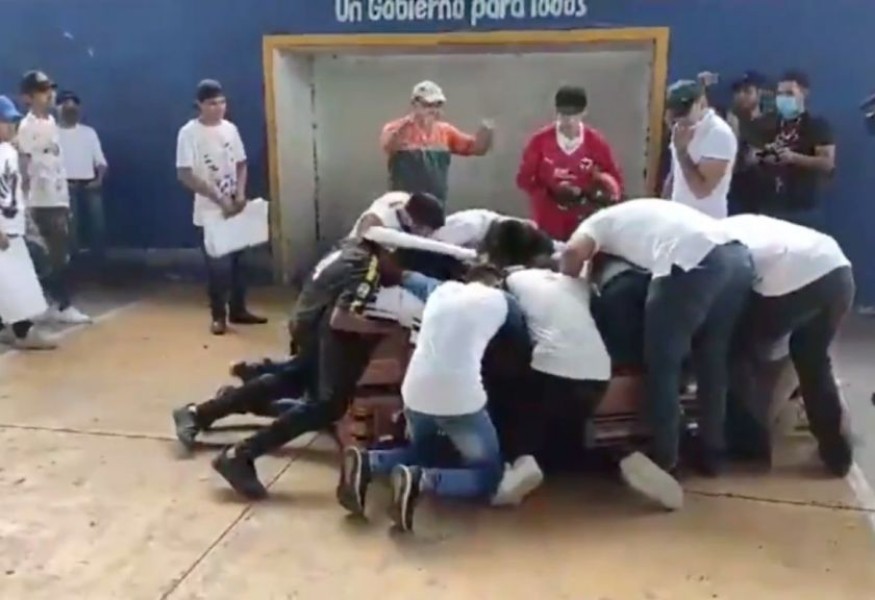 Amigos de Alexander corrieron a abrazar el féretro tras el acto simbólico.