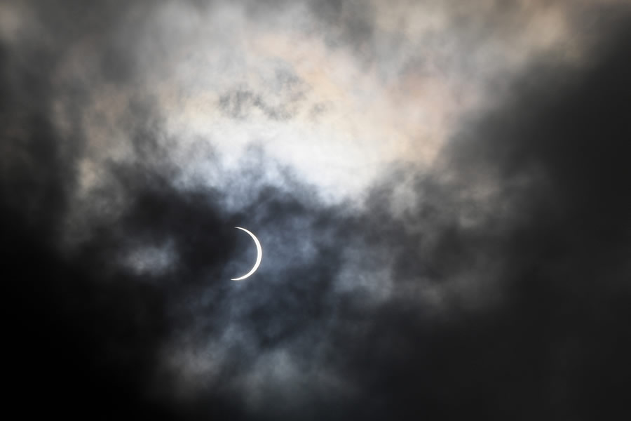 La luna cubre parcialmente el sol durante el eclipse solar anular visto a través de las nubes desde Karachi. (Foto: AFP)