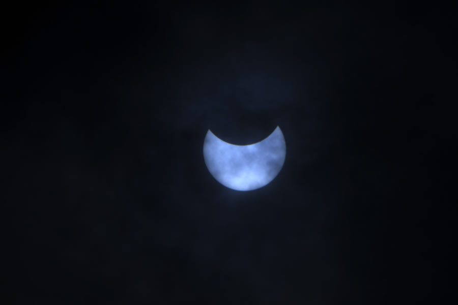 La luna se mueve frente al sol durante el eclipse solar anular visto a través de las nubes desde Katmandú. (Foto: AFP)