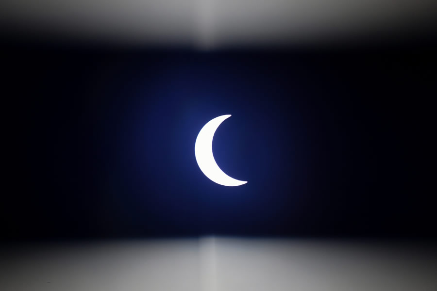 La luna se mueve frente al sol como se ve a través de una tira de plástico oscuro durante el eclipse solar anular visto desde las afueras de Hanoi. (F