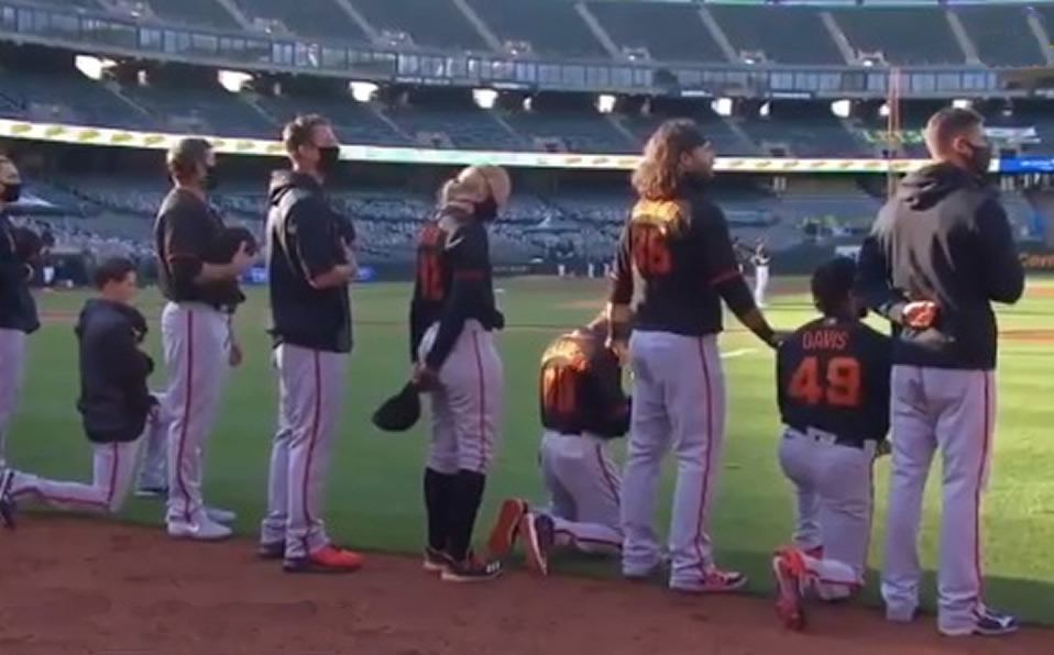 Manager y jugadores de Giants se arrodillan durante el himno