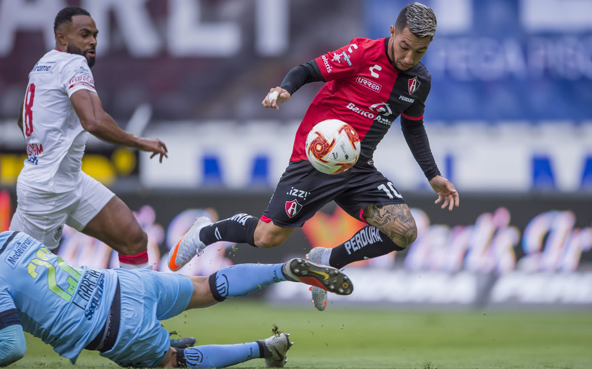 Luciano Acosta es derribado en el área por Luis García en el Atlas vs Toluca. (Foto: Mexsport