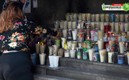 Una mujer enciende veladoras para los muertos por covid. Foto: AFP