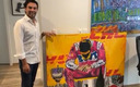 El piloto mexicano posando con la pintura que le regalaron. (Foto: Twitter)