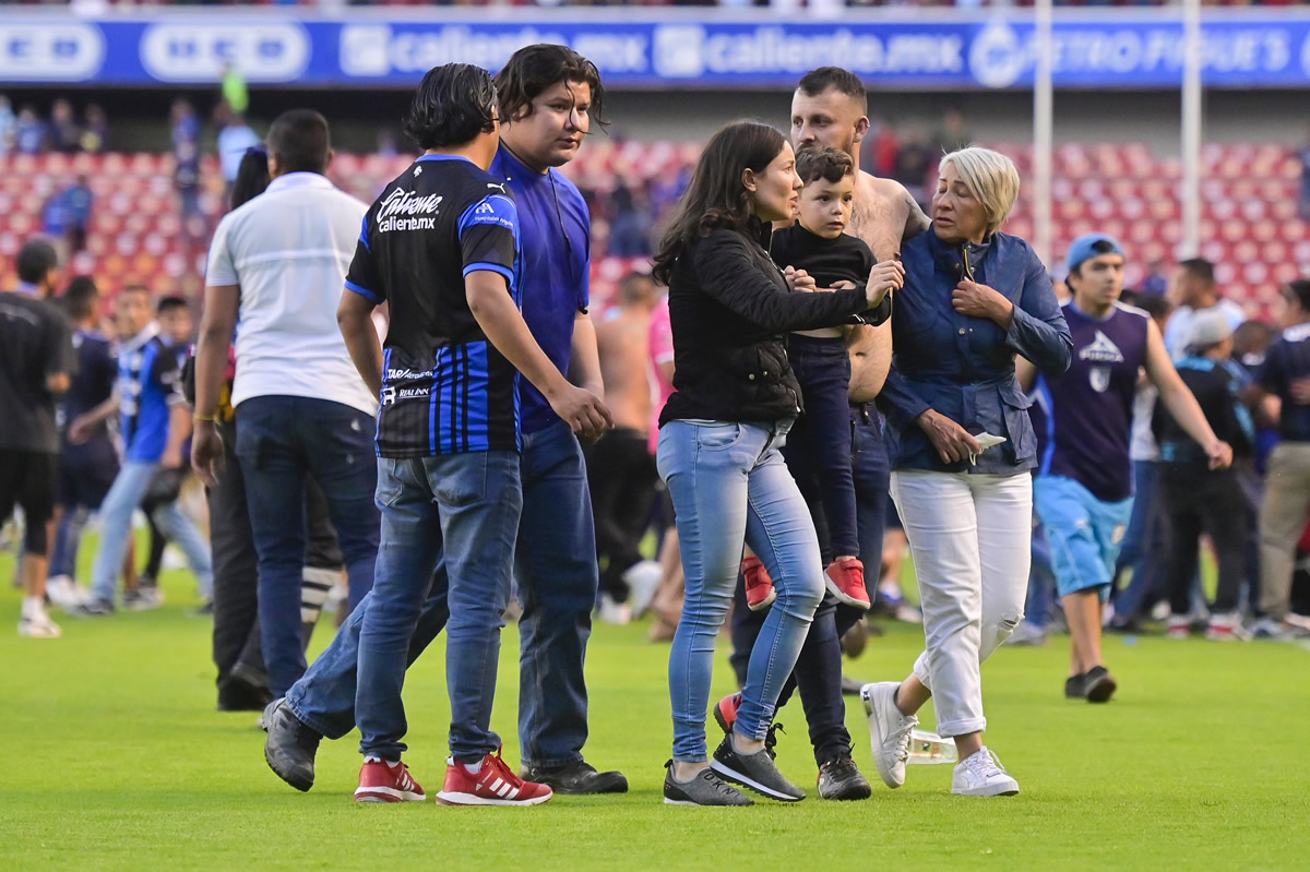 Familias espantadas sobre la cancha.  (Fotos: Mexsport e Imago7).