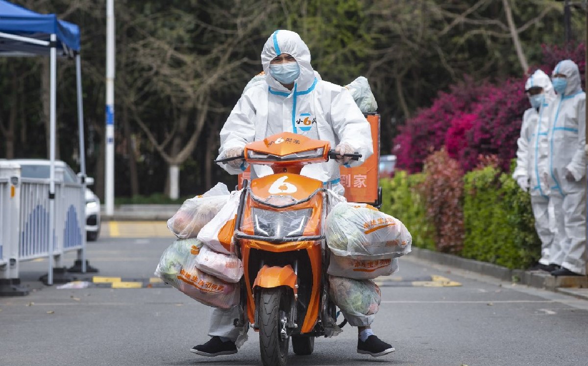 Un repartidor de comida durante la cuarentena por el brote de COVID-19. (FOTO: AFP)