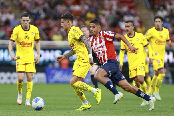 Luis Romo persigue a Brian Rodríguez en el Clásico Nacional (Mexsport)