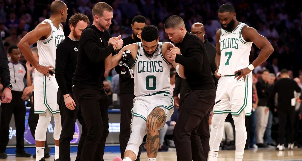 Jayson Tatum recibe ayuda para salir de la duela (AFP)
