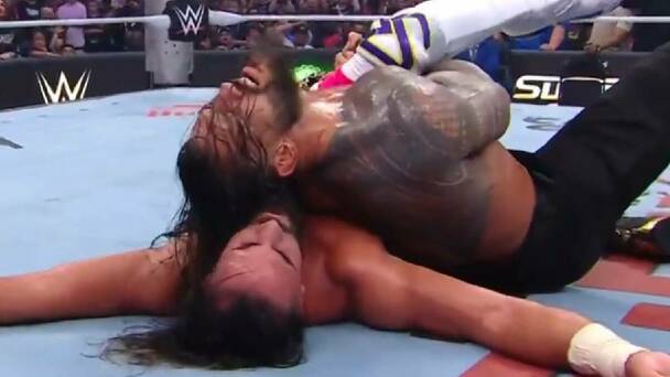 Roman Reigns logra poner en toque de espalda a Seth Rollins para mantener el cetro Mundial Completo en su cintura. FOTO: Captura @WWE