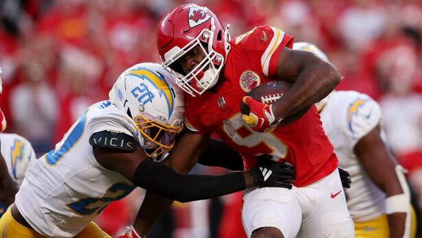 Kenneth Walker III (9) runningback de los Chiefs acarrea el balón ante la presión de Cam Hart. FOTO: Reuters